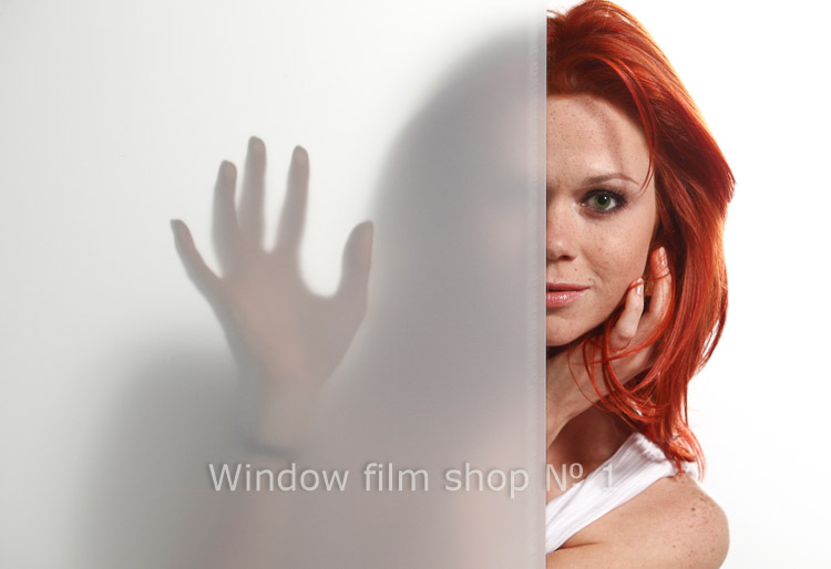 Glass half covered with frosted film: on the left only a silhouette and a hand show through, on the right the clear glass shows a face
