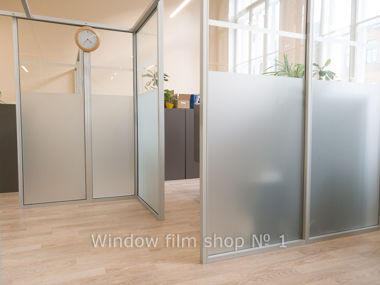 Glass partitions covered with matte white film, daylight passing through the frosted glass